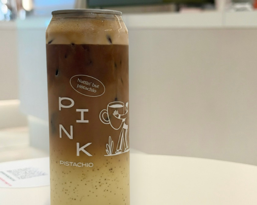 Signature pistachio iced coffee served in a can at Pink Pistachio Brunch in Budapest, layered with espresso, milk and pistachio cream